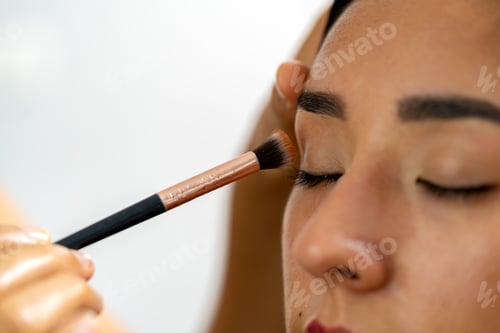Preview: Young latina woman receiving professional eye makeup application
