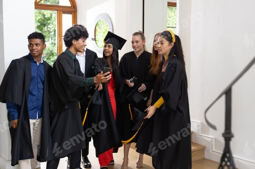 Preview: Graduating students in caps and gowns celebrating together indoors with excitement