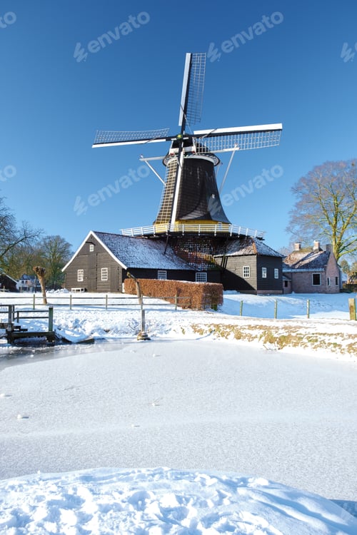 Preview: old historical wooden windmill in the snow in the Netherlands during winter