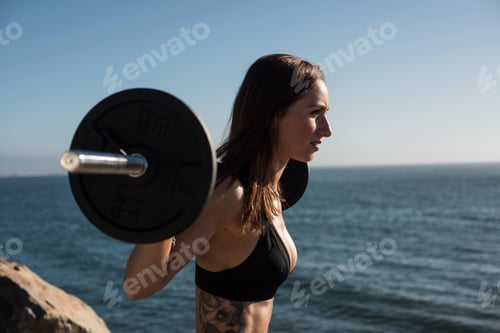 Preview: Fit woman lifting weights - Outdoor