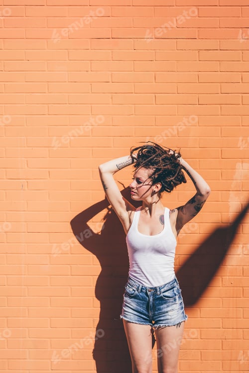Preview: Woman posing against an orange wall