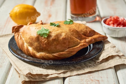 Preview: Traditional baked Argentine empanadas savoury pastries wooden table