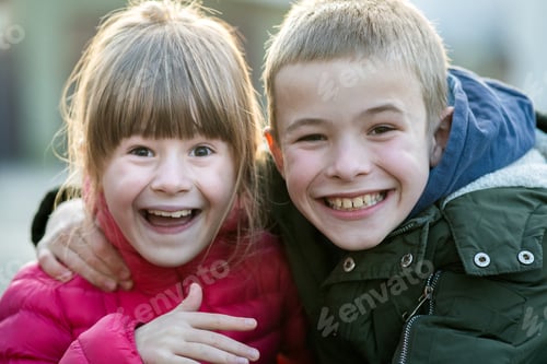 Preview: Two children boy and girl fooling around having fun together outdoors on sunny fall day. Happy