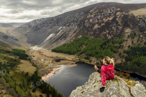 Preview: Woman traveler in a red jacket in the Spink Viewing Spot in Wicklow mountains national park, Ireland