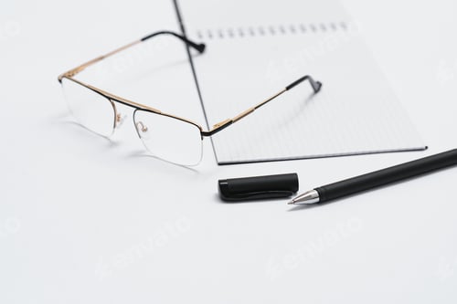 Preview: opened notebook with pen and glasses isolated