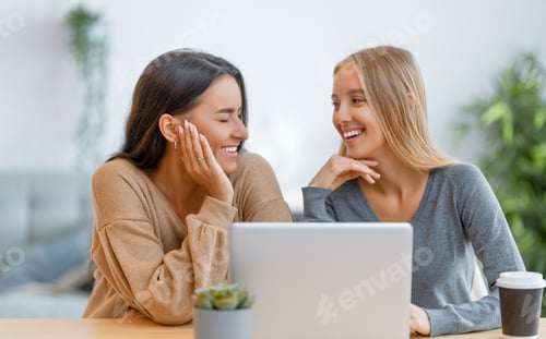 Preview: two happy young women using laptop