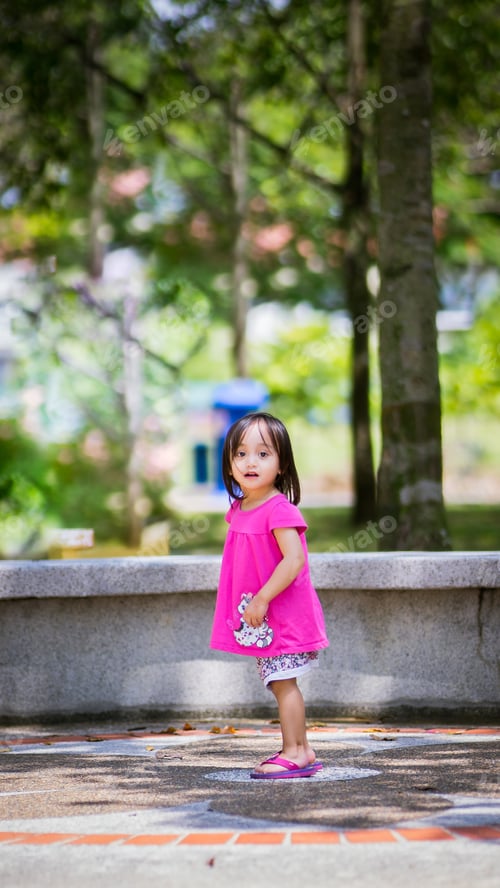Preview: little girl wearing pink dress playing at the park