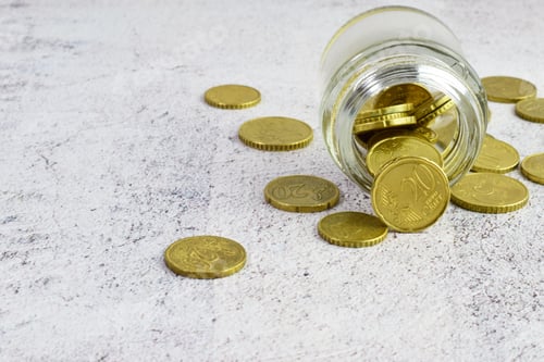 Preview: Closeup shot of coins in a jar on a table
