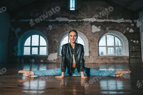 Preview: Contemporary ballet dancer woman in casual style - jeans and leather jacket sitting in twine
