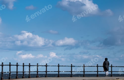 Preview: Lonely person watching endless sea and sky from the pier