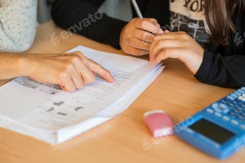 Preview: Mother assisting daughter in homework at desk