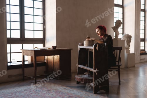 Preview: Woman Sculpting Clay in Sunny Studio by Window