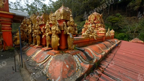 Preview: Malaysian temple with golden statues of the saints. Action. Concept of religion and culture.