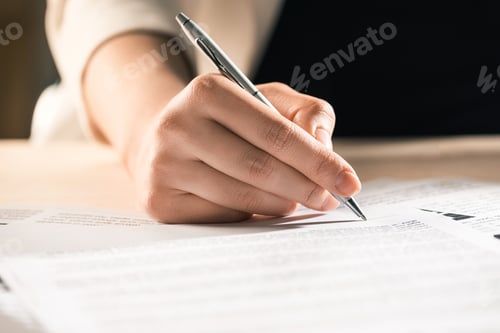 Preview: cropped view of businesswoman signing contract documents sitting at table