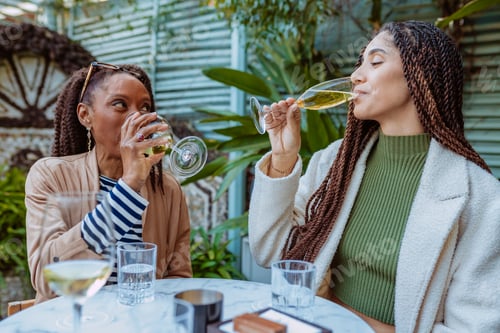 Preview: Two women enjoying drinks at outdoor cafe