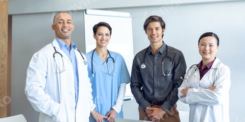 Preview: Front view of happy diverse medical team looking at camera in conference room of hospital