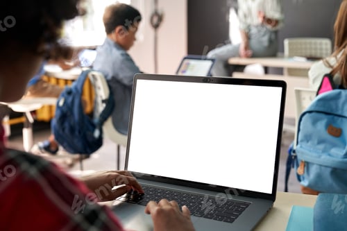 Preview: African American school kid girl using laptop computer with white mockup screen.