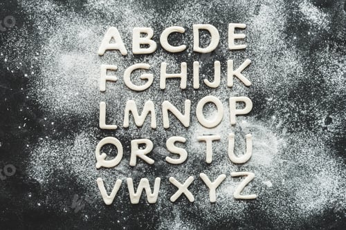 Preview: top view of dough for cookies in forms of letters with flour, cookie dough