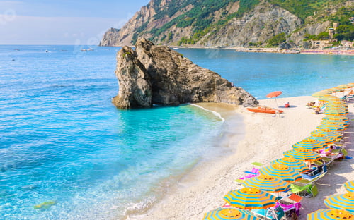 Preview: Pebble beach Monterosso vacation Chairs and umbrellas on the beach of Cinque Terre Italy.