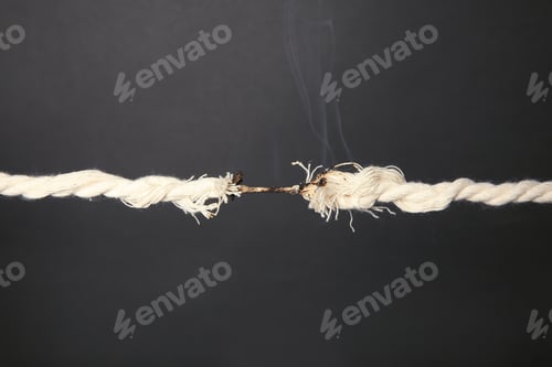 Preview: Burning frayed rope at breaking point on gray background