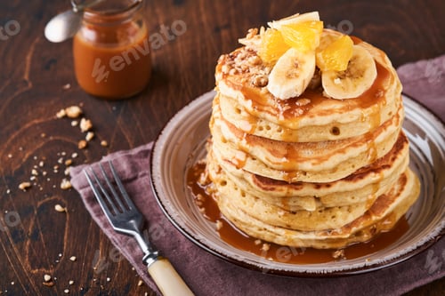 Preview: Pancakes. Homemade fluffy pancake with banana, walnut and caramel for breakfast on dark wooden backg
