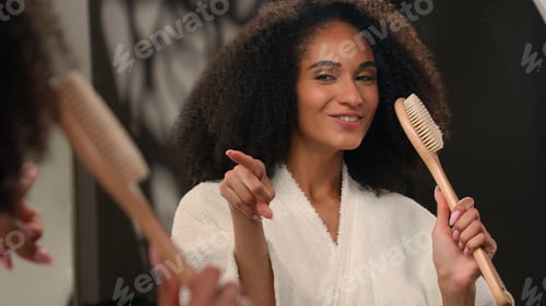 Preview: Close up female reflection singing happy carefree African American woman cheerful sing in bath brush