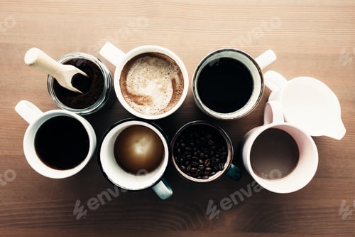 Preview: Multiple coffee cups, milk, beans and ground coffee in jar on wooden background