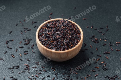 Preview: Black rice in wooden bowl surrounded by scattered grains