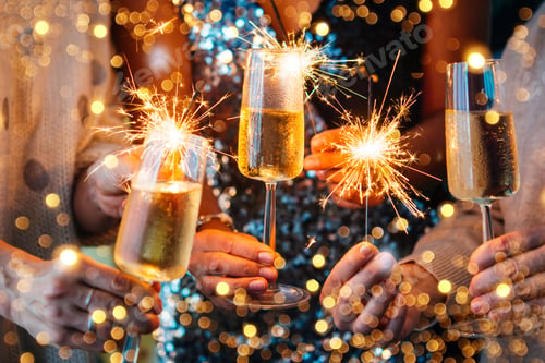 Preview: Adults Holding Champagne Glasses and Sparklers at Celebration