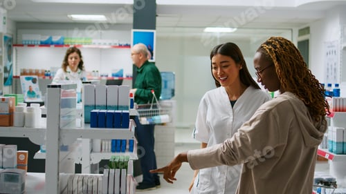 Preview: Asian pharmacist talking to diverse customers with disease