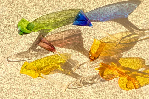 Preview: Top view over summer trendy liquoir glasses over leather textured background. Summer holidays, party