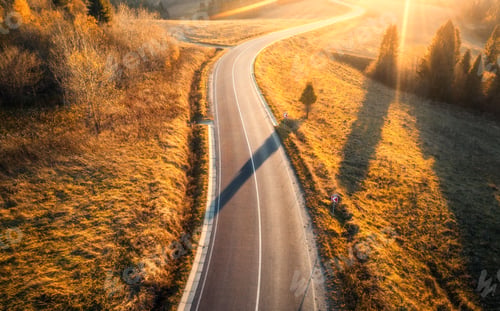 Preview: Aerial view of mountain road in orange forest at sunset in autumn