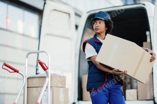 Preview: African American delivery woman unloading boxes from a truck.