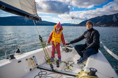 Preview: Father instructing daughter on sailing a yacht during training in the Kotor Bay, Montenegro