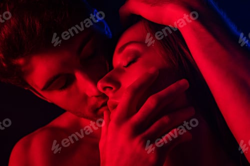 Preview: passionate undressed sexy man kissing woman in red light