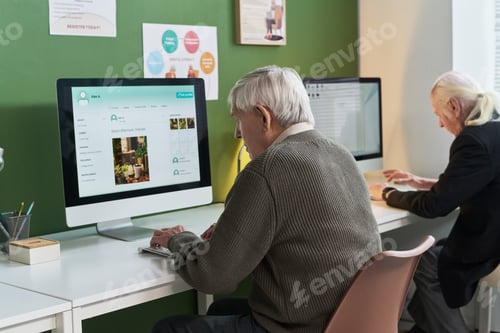 Preview: Senior Caucasian Men Attending Computer Literacy Course Using Desktop Computers