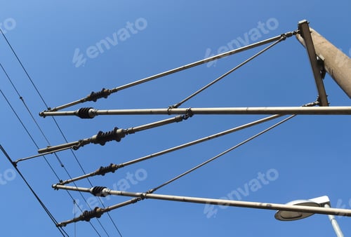 Preview: Low angle shot of a uniquely designed electrical post with the clear blue sky on the background