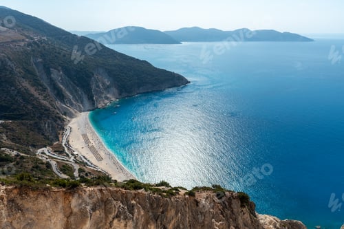 Preview: Tropical beach view with crystal clear water with tourist people on the shore. Myrtos famous beach