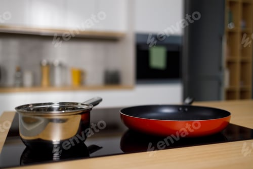 Preview: Empty frying pan and sauce pan on induction cooktop