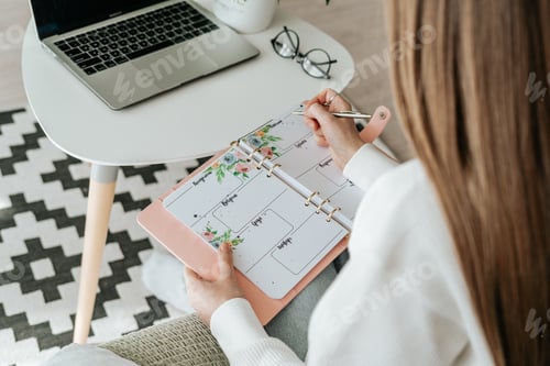 Preview: Business woman working at laptop and writing in notebook