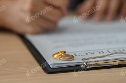 Preview: Wedding rings placed on top of legal documents signify a separation.