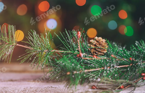 Preview: Christmas decorations on a Christmas tree branch over blurred shiny background. Selective focus.