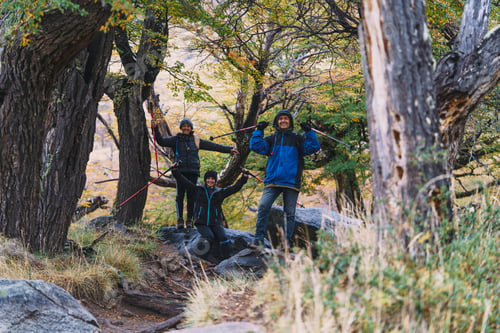 Preview: Three people are posing for a photo in a forest
