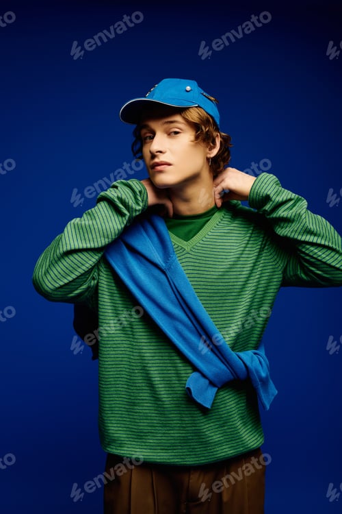 Preview: Young man displays vibrant fashion trends with stylish accessories in a studio