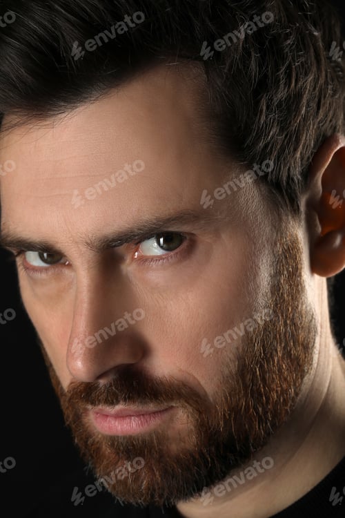 Preview: Evil eye. Man with scary eyes on black background, closeup