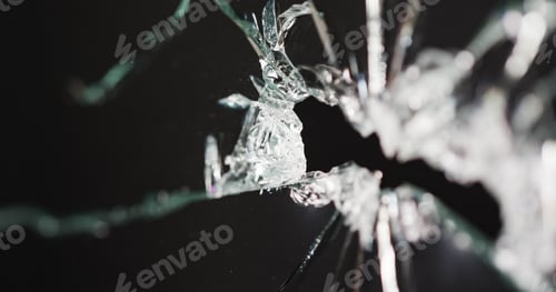 Preview: Close up of broken, cracked pane of glass with hole, on black background with copy space
