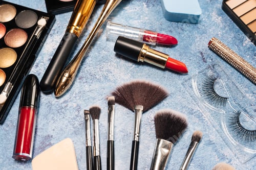 Preview: set of decorative cosmetics, makeup brushes on a blue background. the view from the top