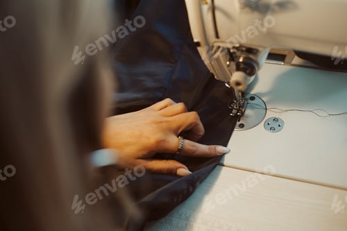 Preview: Woman tailor hands working on sewing machine.
