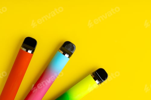 Preview: Colorful disposable electronic cigarettes on yellow background