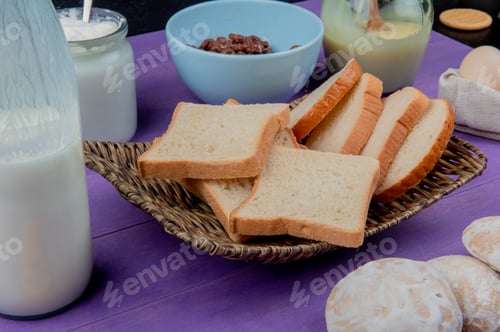 Preview: side view of white bread slices in basket plate with milk products and cookies, cereals, eggs